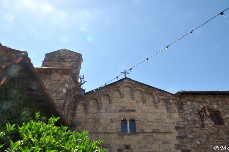 Castello Di Amorosa: каменная арка с крестом под ясным небом
